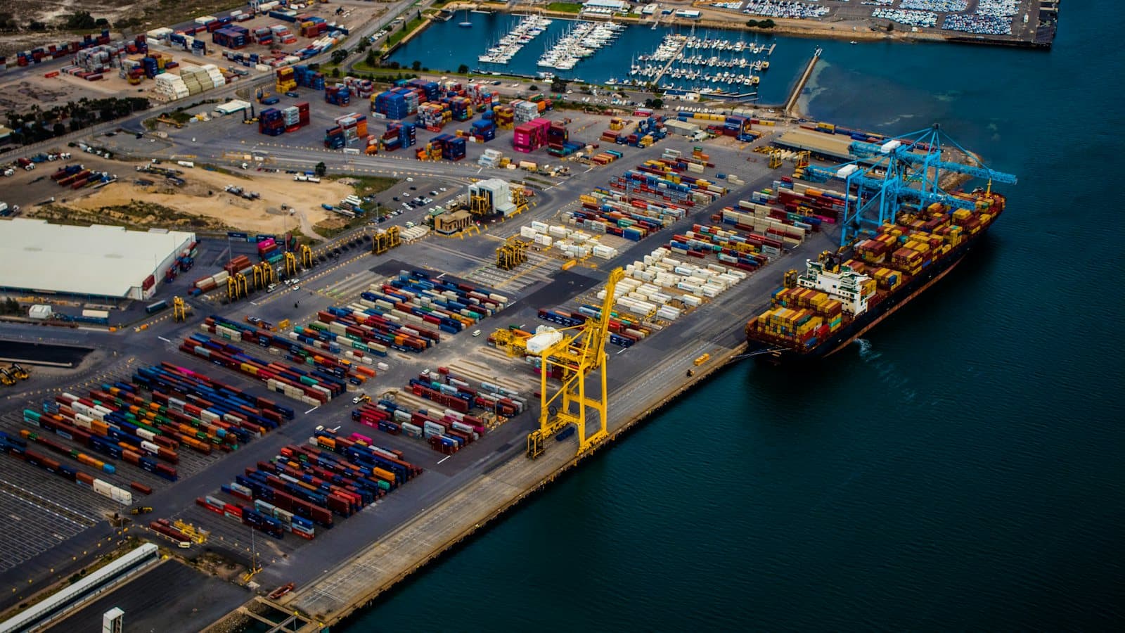 Container ship at berth next to a container yard, seen from above